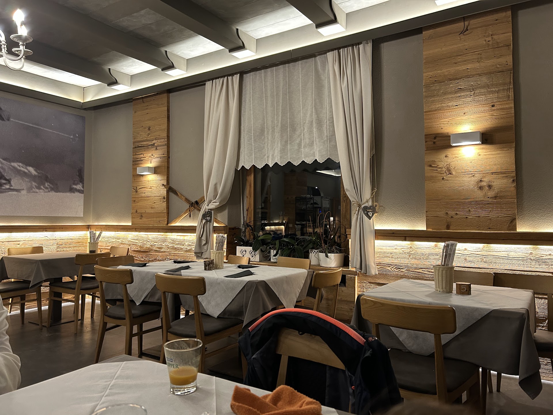 Sala del Ristorante Pizzeria Esperia a Lavarone, boiserie in legno e tavoli apparecchiati